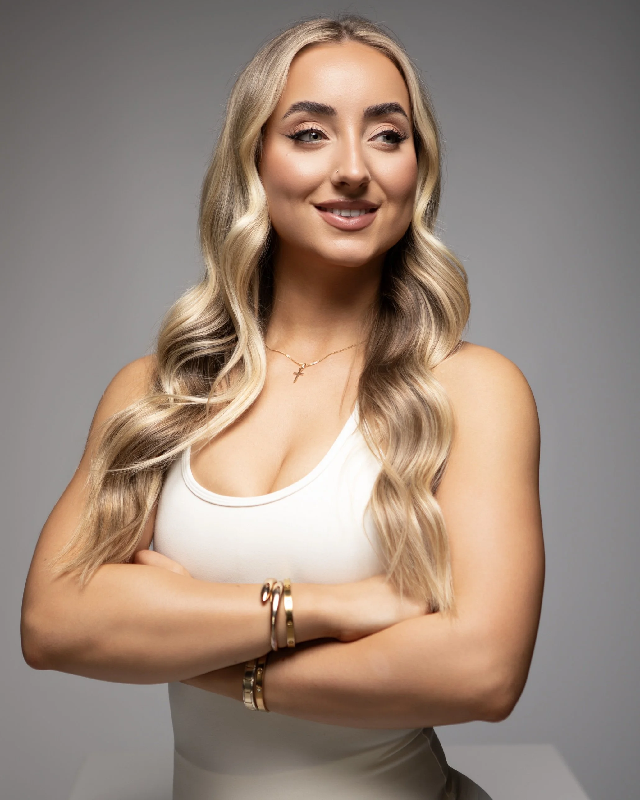Olivia Strauss, founder of Olura Coaching, smiling in a white activewear set.