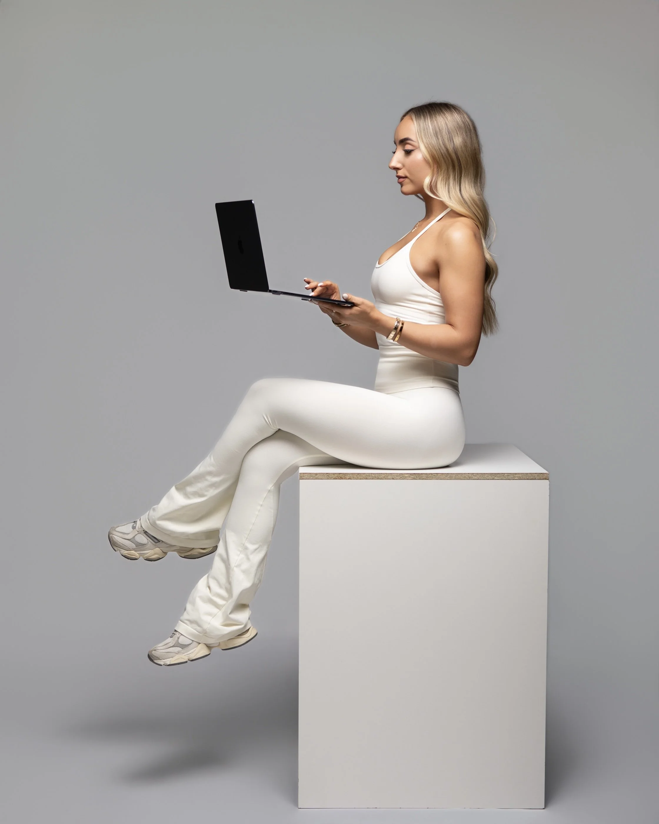 Founder of Olura Coaching using a laptop to provide personalised online fitness coaching for women.