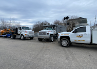 Line of service trucks parked outdoors on a cloudy day.