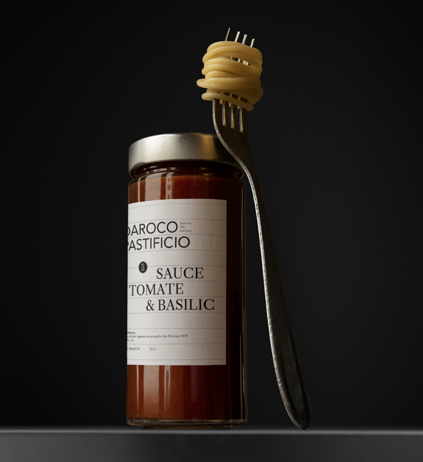 Un bocal de sauce tomate et basilic avec un fourchette en équilibre dessus, autour de laquelle est enroulée une quantité de spaghetti.