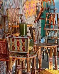 Collection de chaises en bois et en osier avec un coussin, dans un décor coloré.