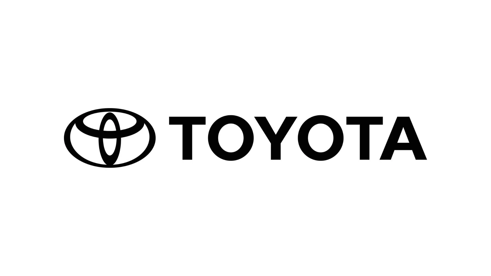 Das Bild zeigt das schwarze Logo der Automarke Toyota, bestehend aus einem stilisierten Ellipsen-Design, neben dem der Schriftzug "TOYOTA" in Großbuchstaben.