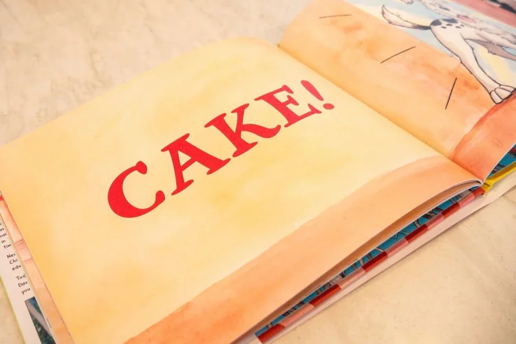 The book open to the page that reads CAKE!
