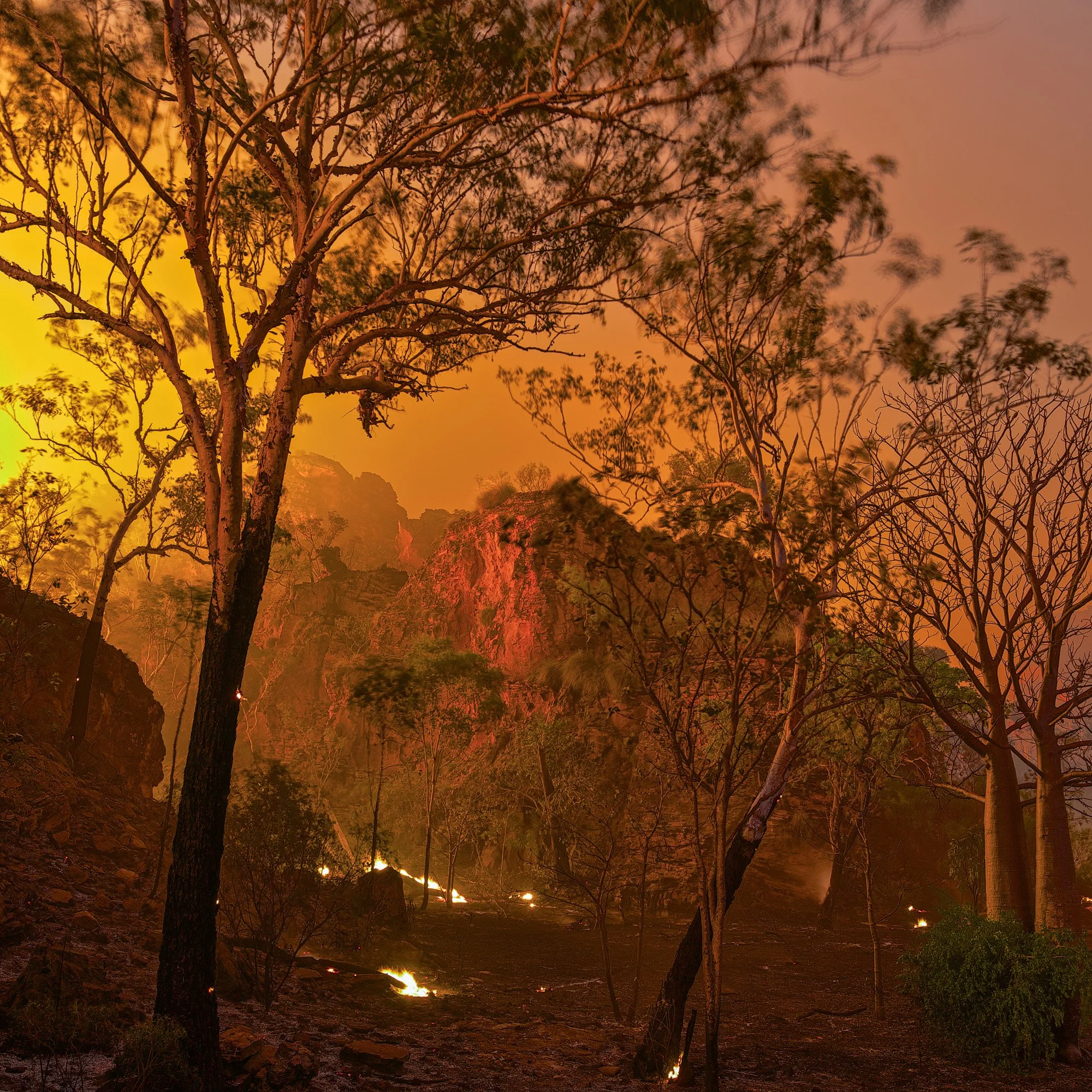 Deep within Mirima National Park, fire moves through the landscape after sunset, transforming the sandstone country with an intense, otherworldly glow.