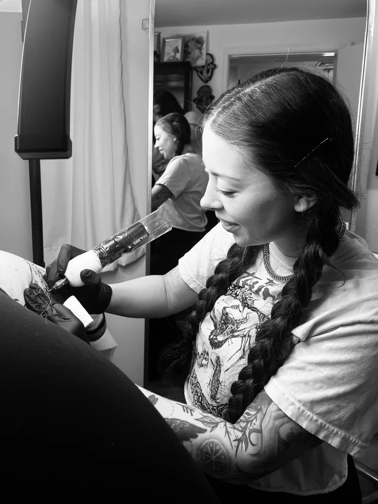 Happy female artist working on a tattoo
