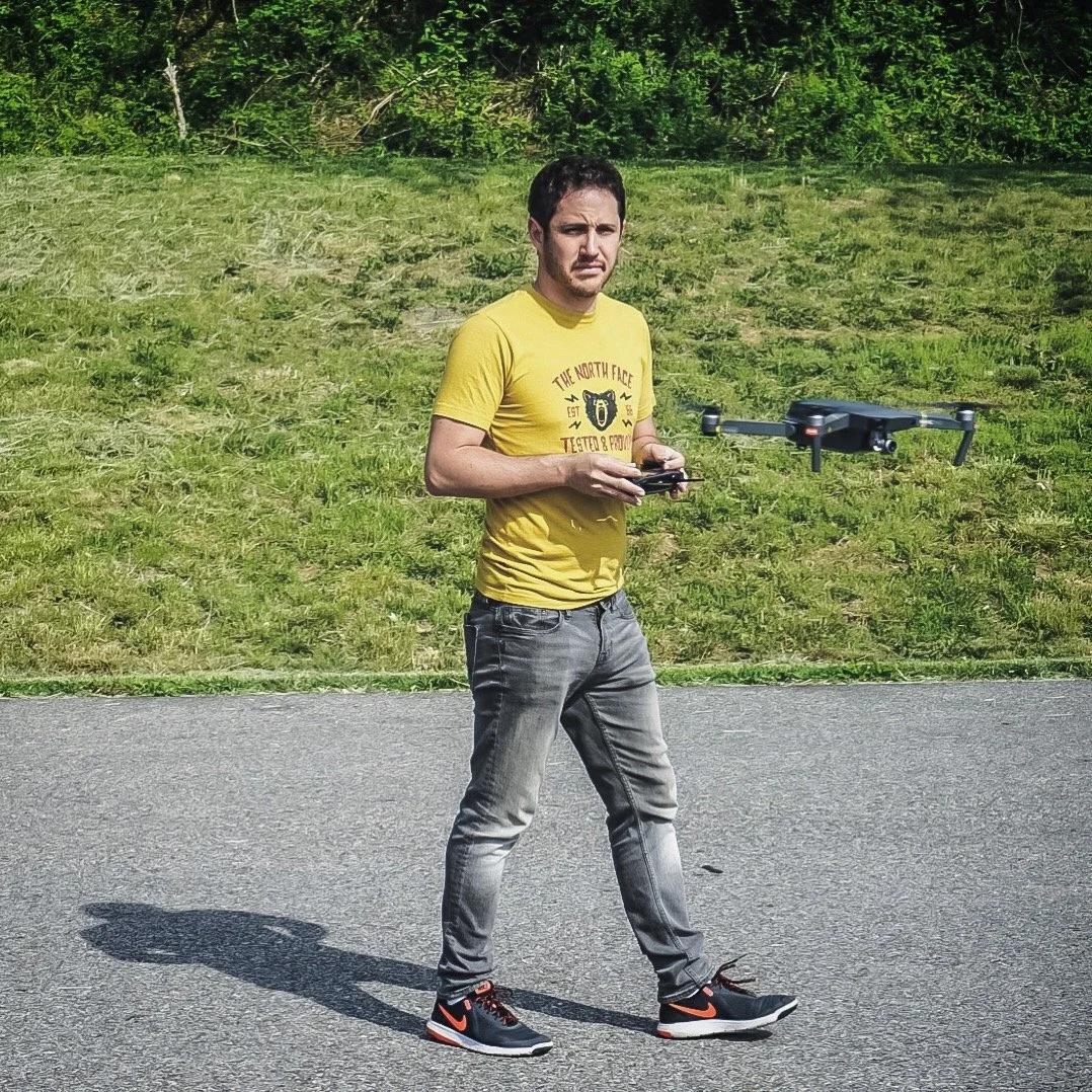 Arnaud Muller piloting a drone beside a green hillside