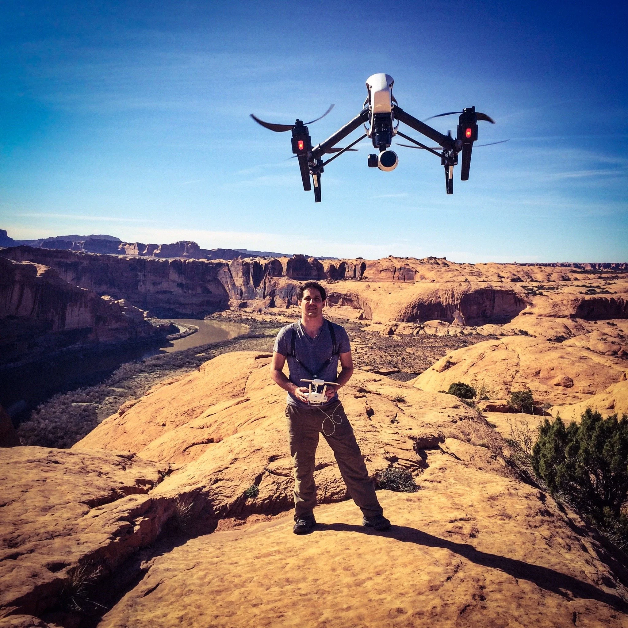 Arnaud Muller piloting a drone above a sunlit desert canyon