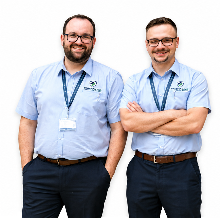 Two smiling men in light blue uniforms with company logos and ID badges standing against a white background.