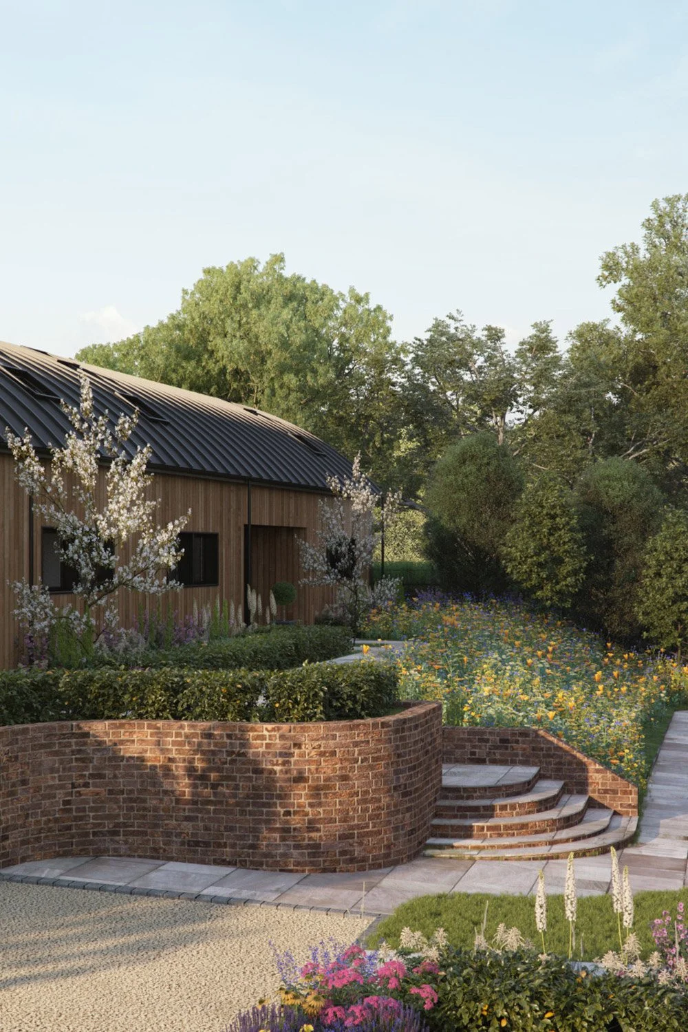 A landscaped garden with a brick retaining wall, steps, flowering plants, trees, and a modern wooden building with a curved metal roof in the background.