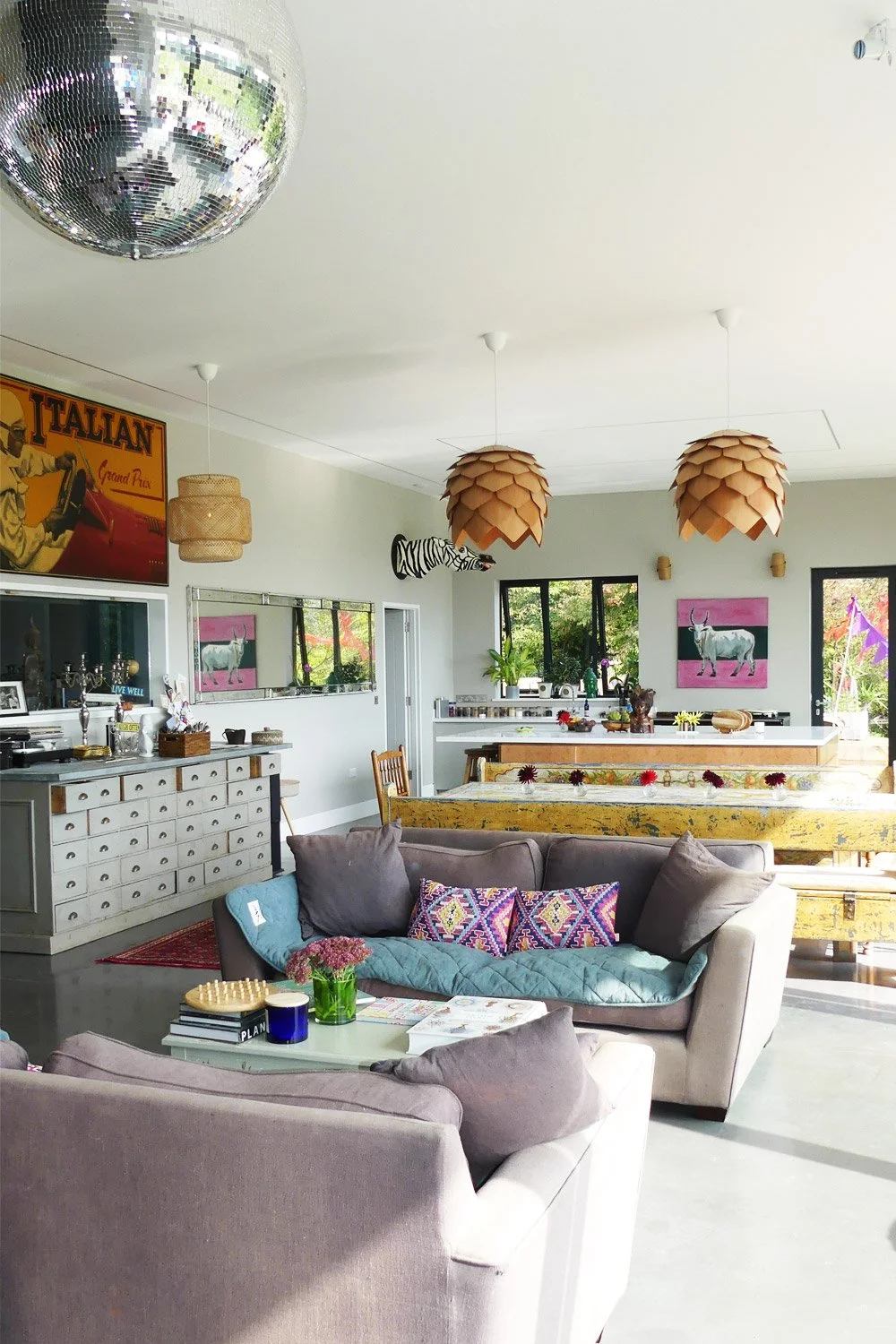 Bright, colorful living room with sofas, artwork, and decorative lighting fixtures.