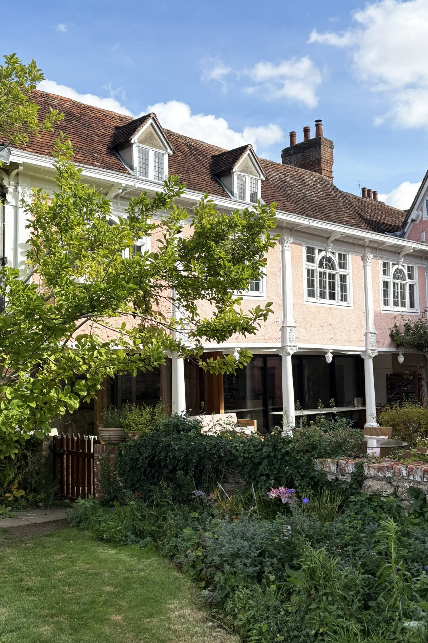 Manor house courtyard with hidden contemporary slim-line sliding doors create a glazed wall integrating inside and outside.