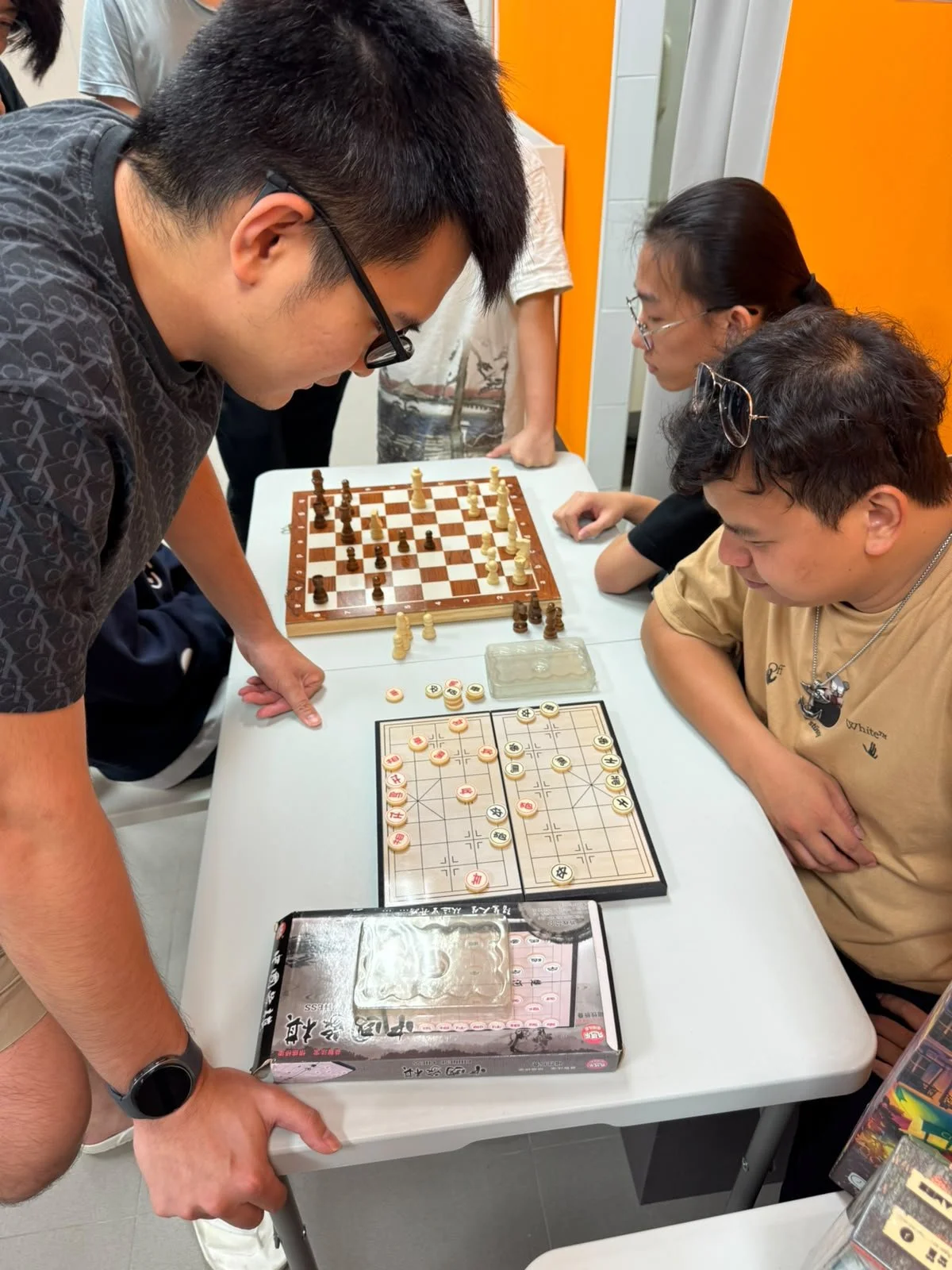 People playing Chinese chess and International chess.