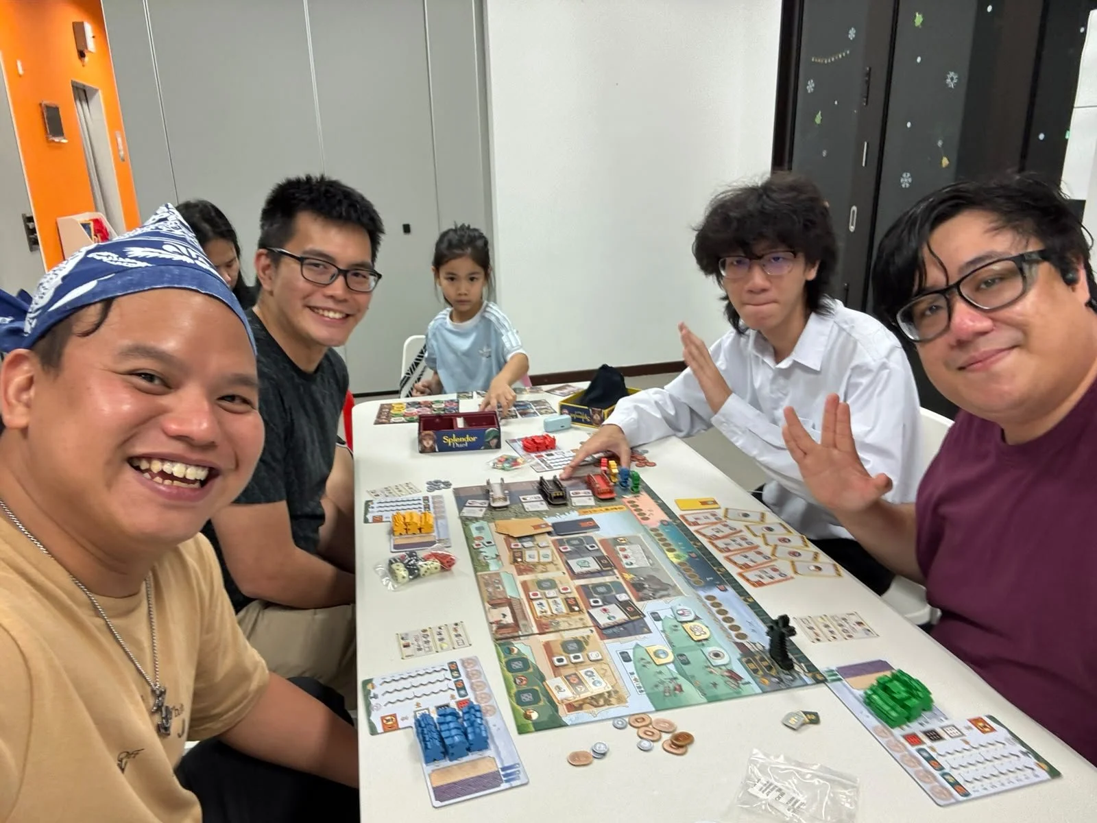 A group of four people playing a board game (White Castle).