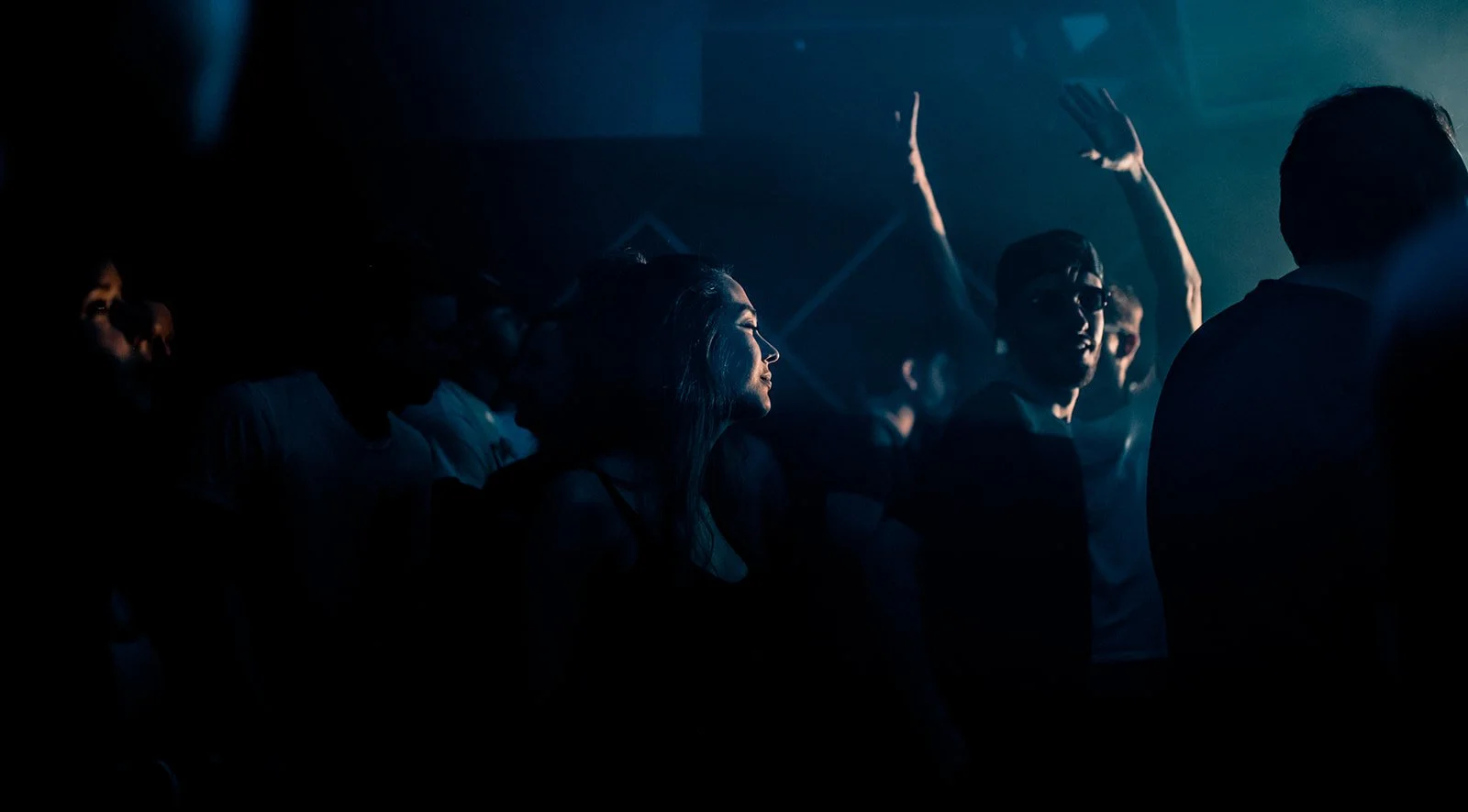B2 Photography Jakob Hallaert  - Mensen genieten van een concert of clubavond in een donkere sfeer met blauwe verlichting.