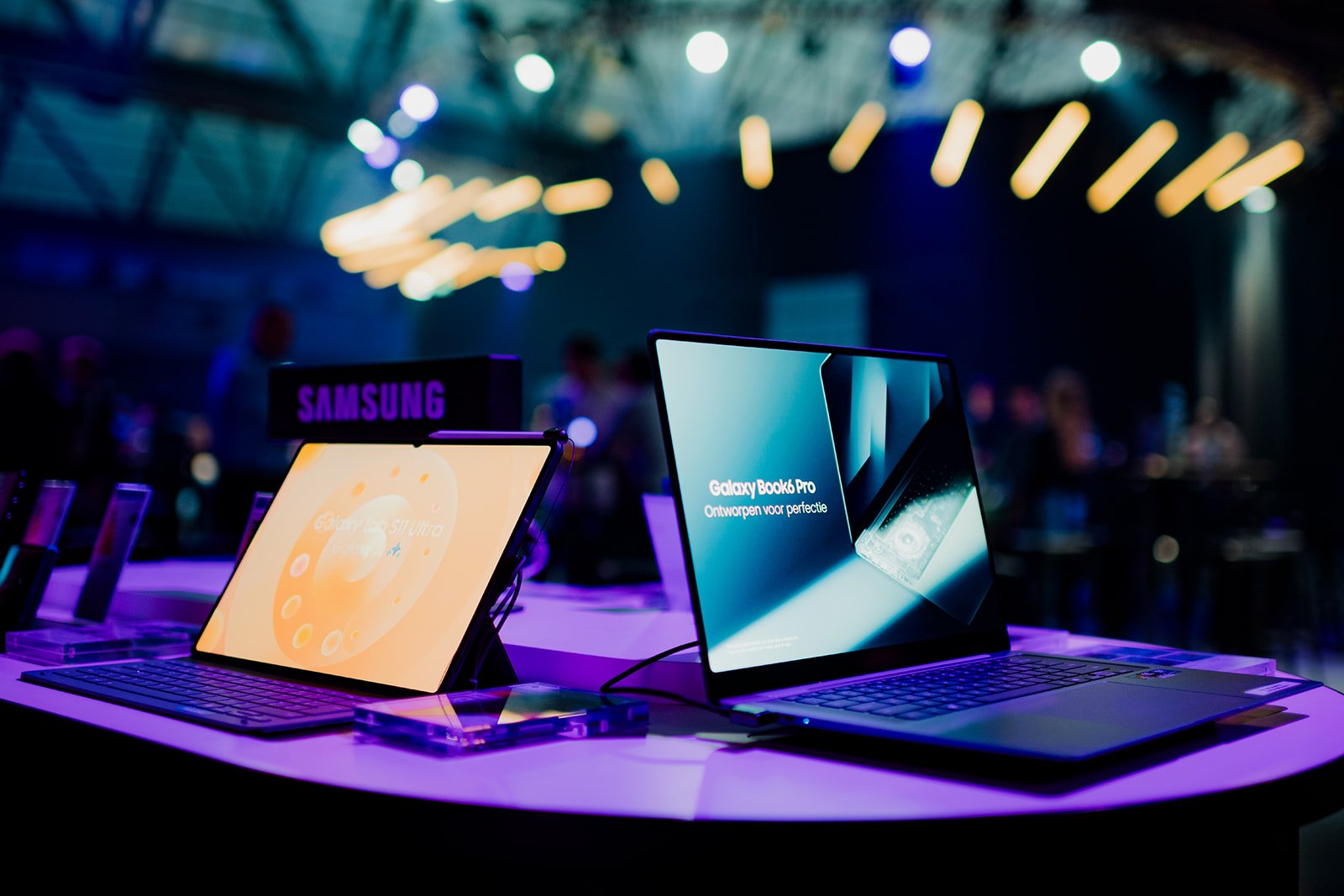 B2 Photography Jakob Hallaert  - Twee laptops op display bij een tech event, met het Samsung logo zichtbaar in de achtergrond.