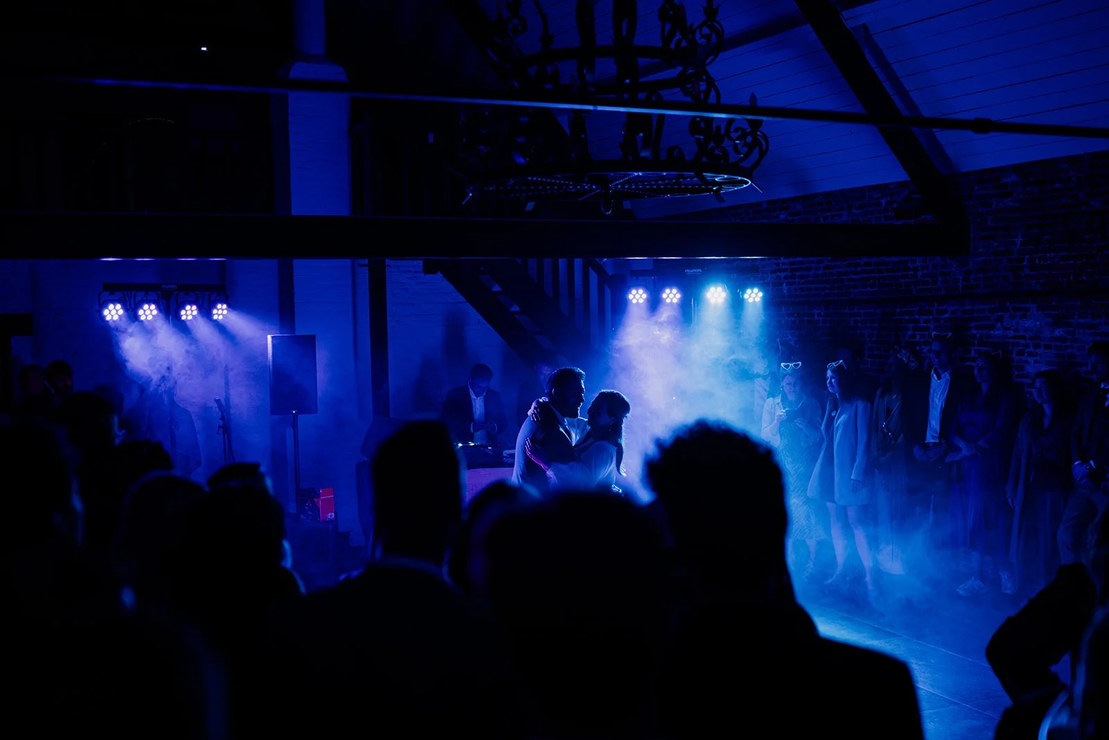 B2 Photography Jakob Hallaert  - Twee mensen die dansen op een feest met blauw verlichte sfeer en anderen die toekijken.