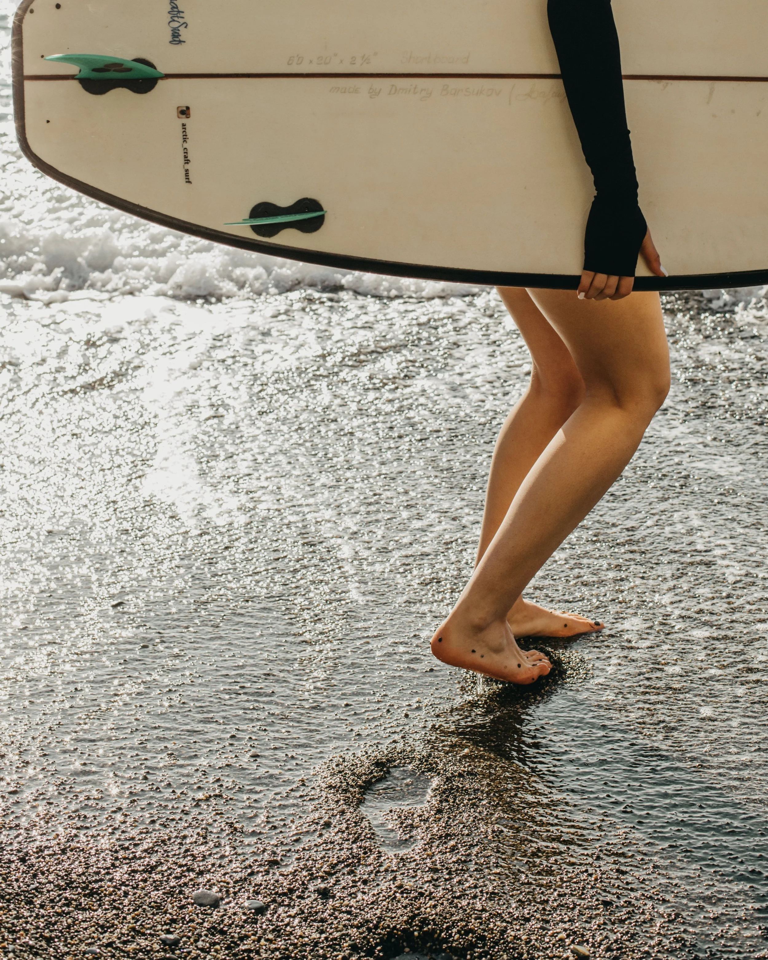 Woman holding a surfboard on the beach
