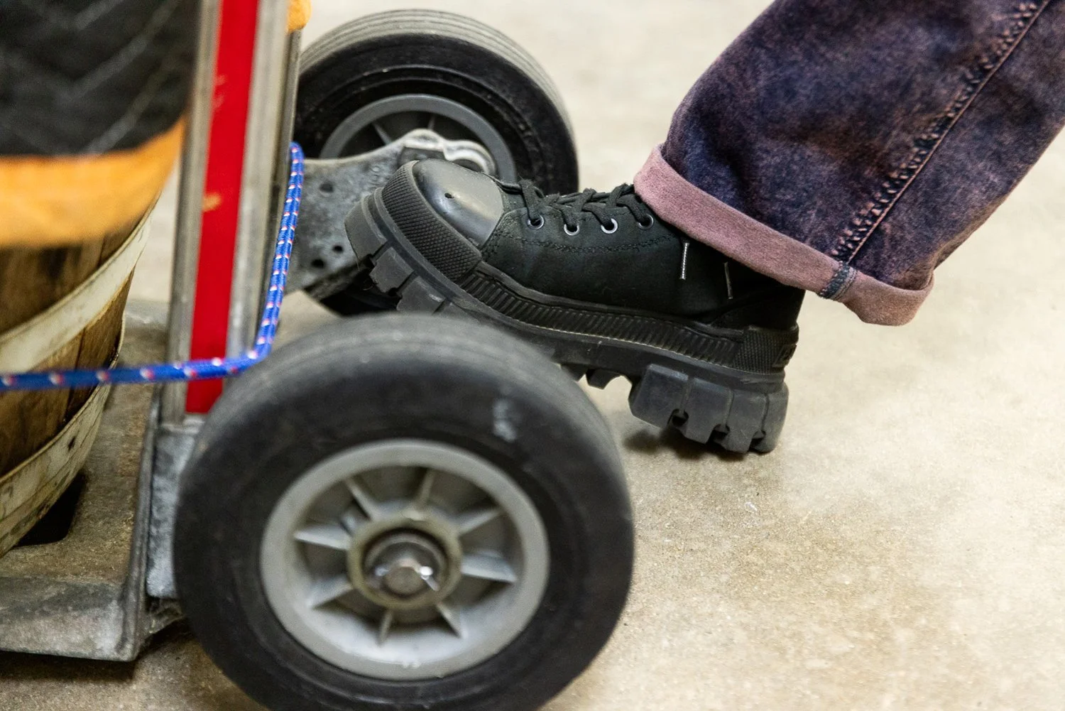 Close-up of a person's foot wearing a black shoe on a small wheelchair.