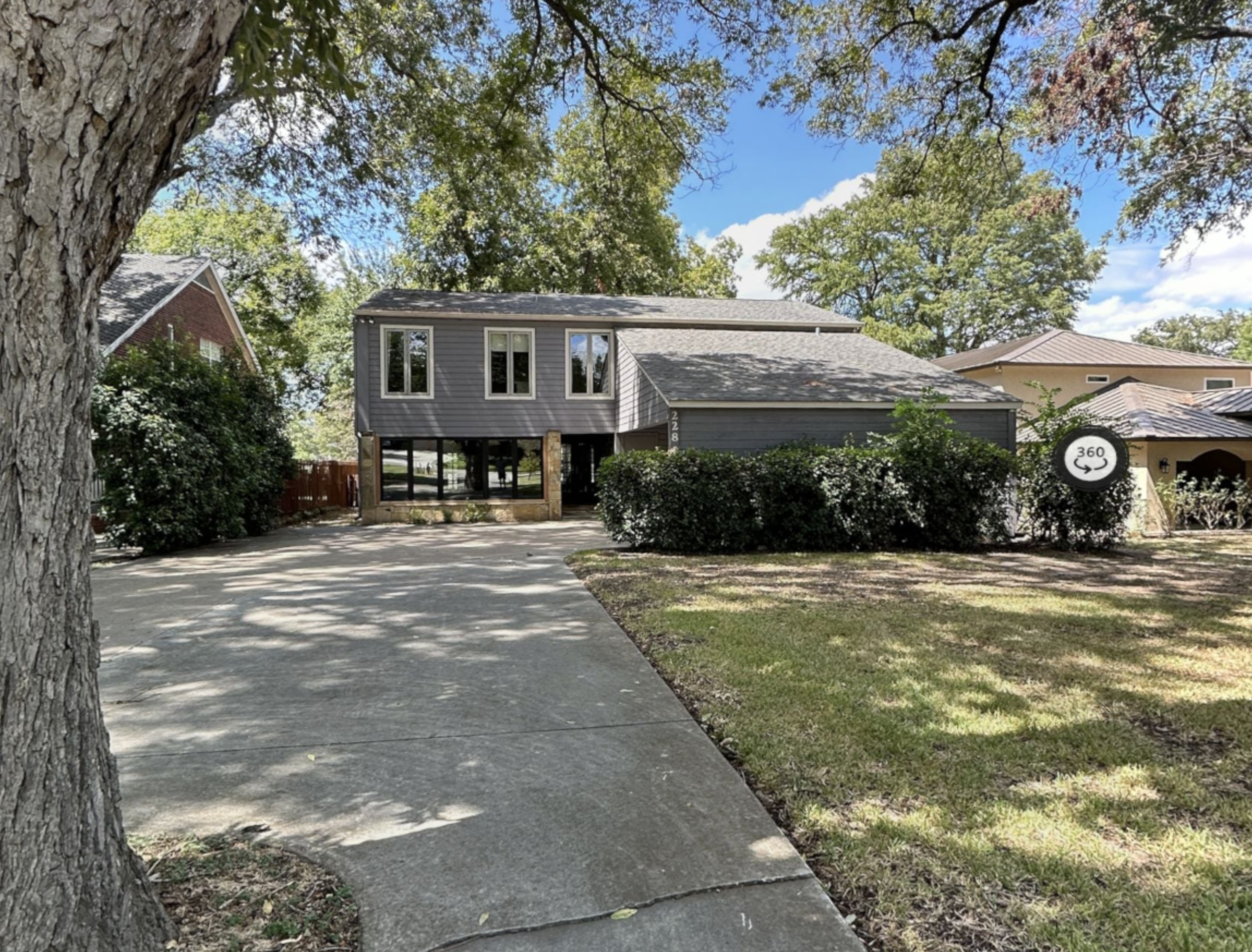 Before photo of the Lake McQueeney Residence showing the original 1980s waterfront home exterior prior to renovation by Burleson Architecture.