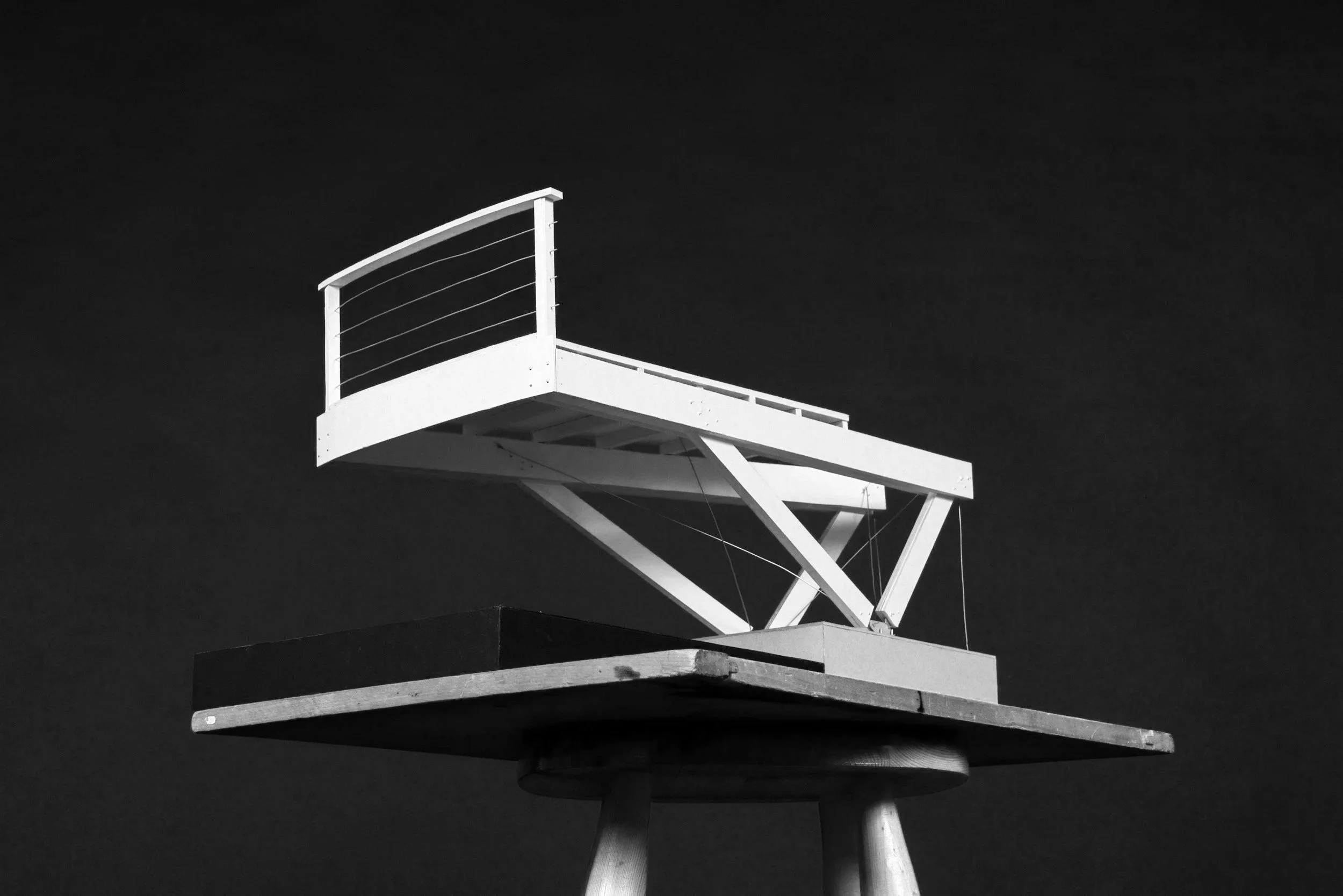 Black and white photo of a lifeguard tower against a dark sky.
