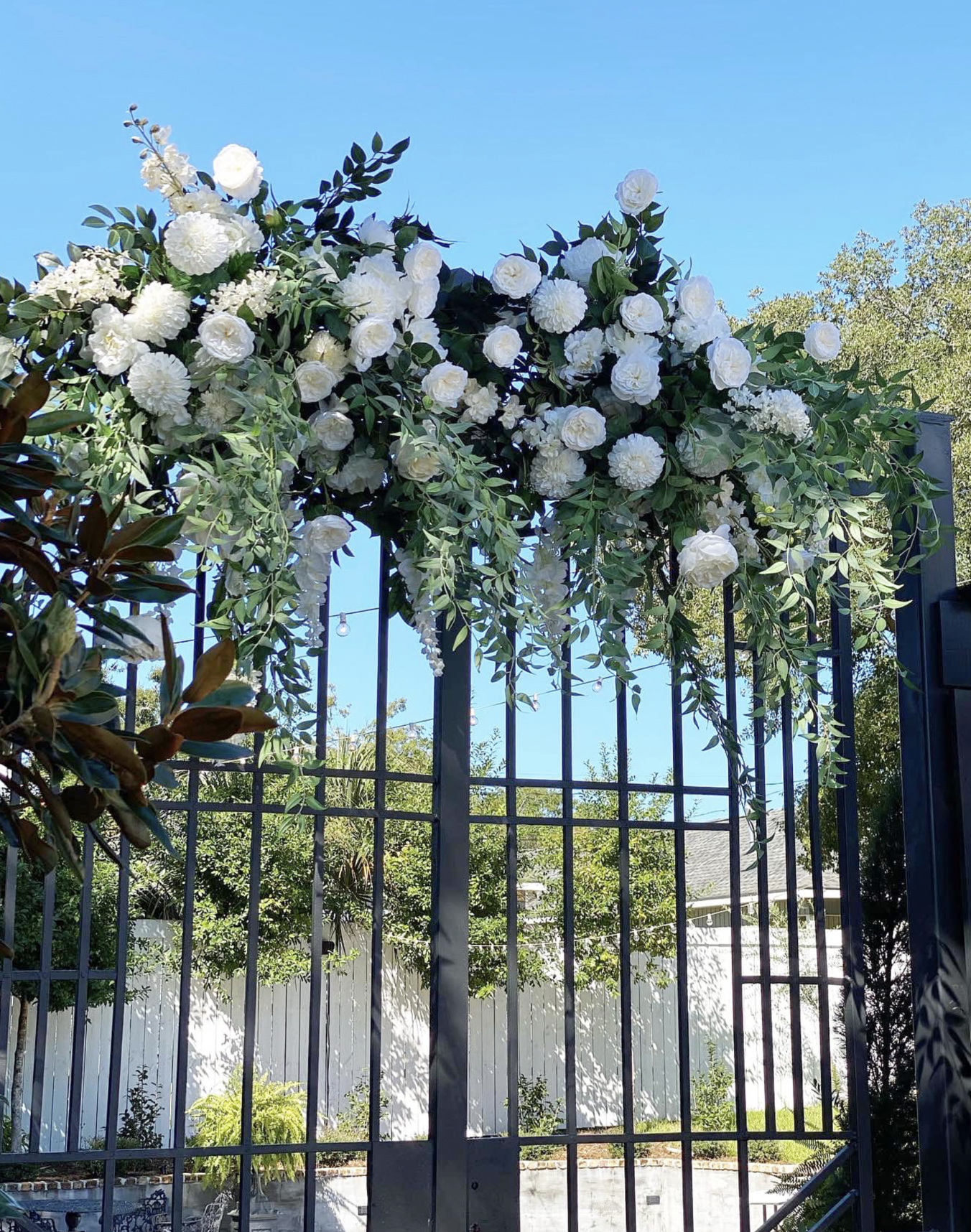 White flowers arranged on a metal gate.
