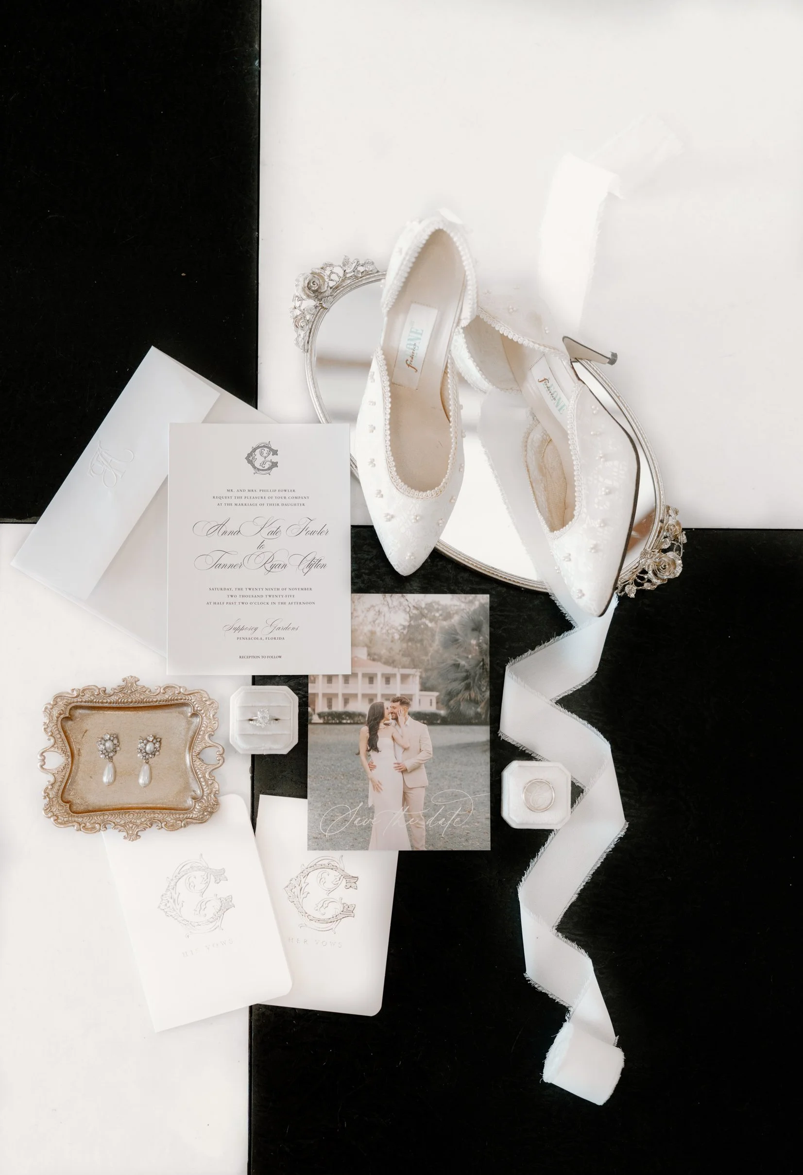 Wedding accessories including white embroidered shoes, pearl earrings, wedding invitation, engagement ring, wedding photograph, and decorative ribbons and jewelry