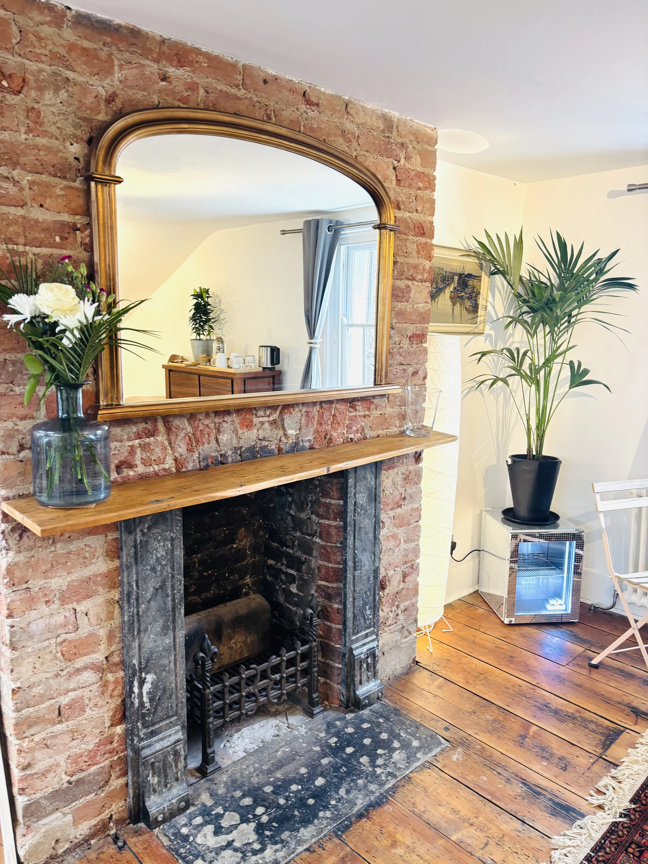 Original fireplace and mirror in a guest room at Central Victorian House