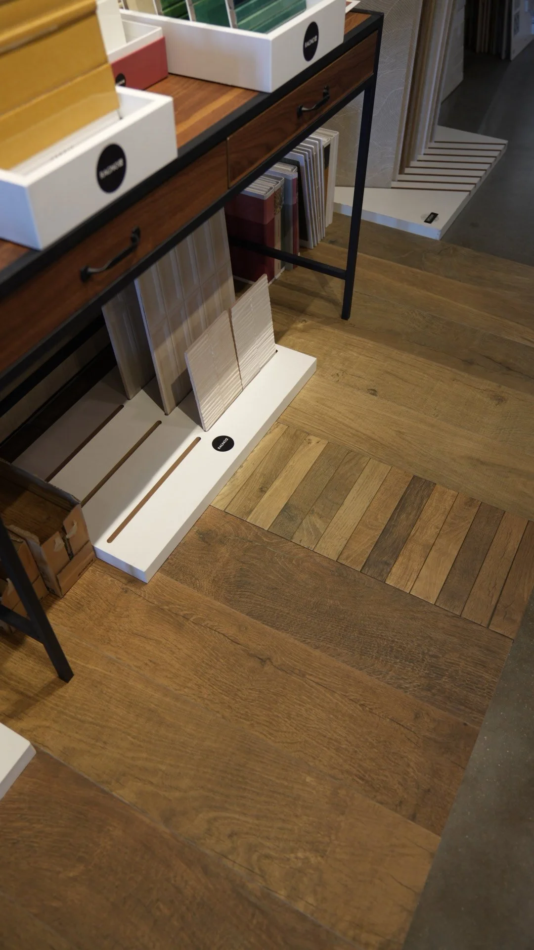 Display of wood flooring samples and tile samples on shelves in a store.