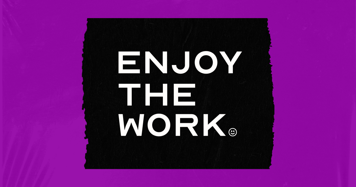 A black rectangular sign with the words 'Enjoy the Work' written in white capital letters, on a purple background.