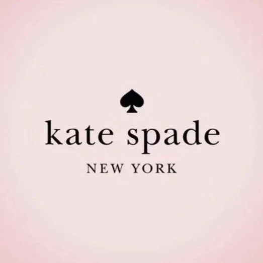 Logo of Kate Spade New York with a black spade symbol above the text on a light pink background.