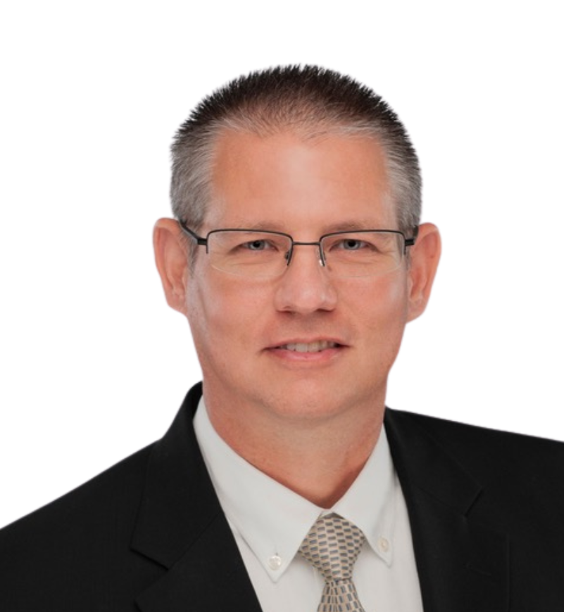 A professional headshot of a man with short, gray hair wearing glasses, a black suit, white shirt, and a patterned tie, against a white background.