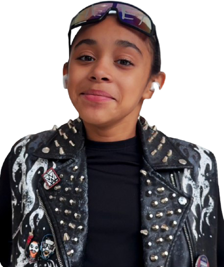 Young girl with glasses, earbuds, black and silver studded leather jacket, and a black shirt, smiling slightly.