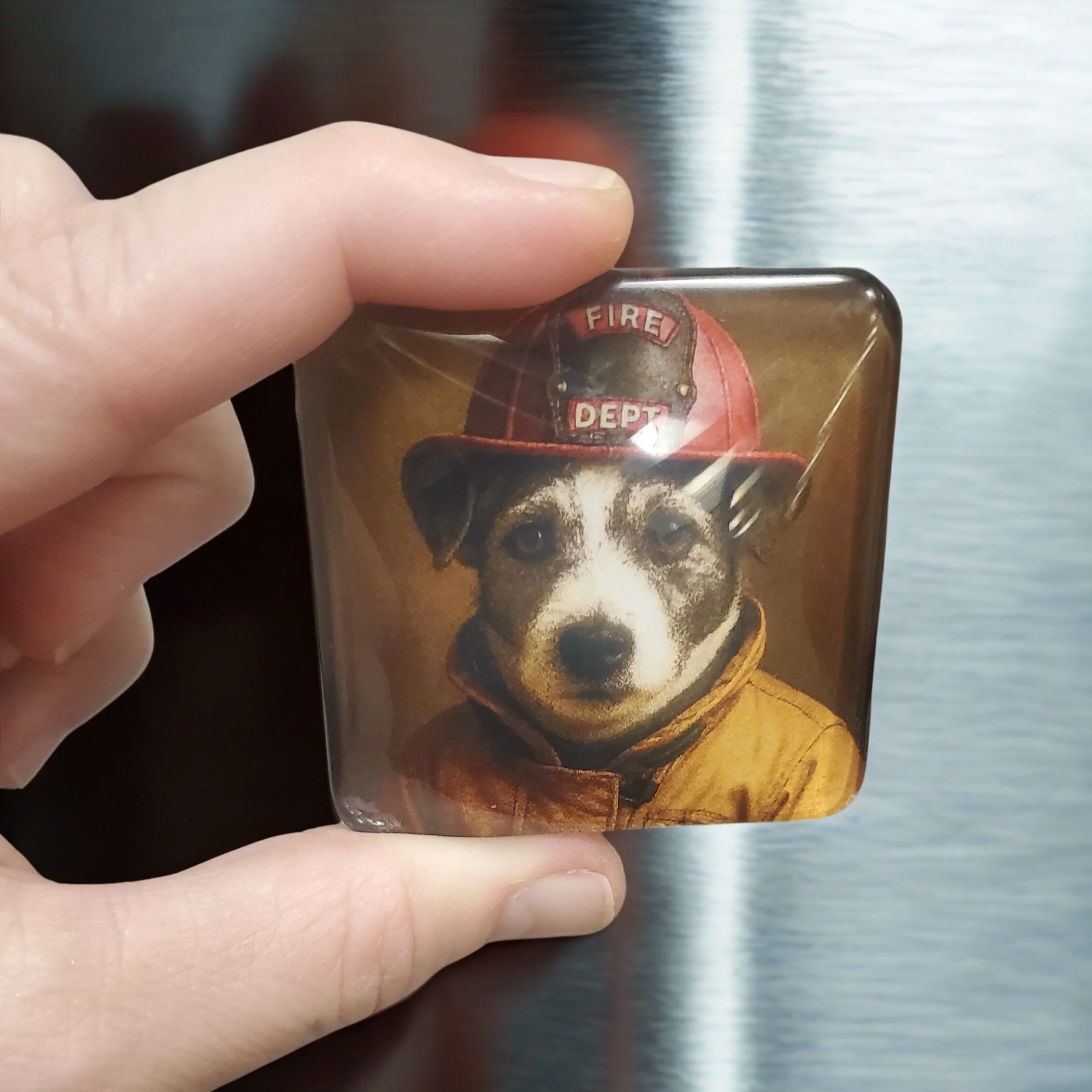 Custom handmade 2-inch glass magnet featuring a personalized dog portrait wearing a firefighter helmet, displayed on a refrigerator.