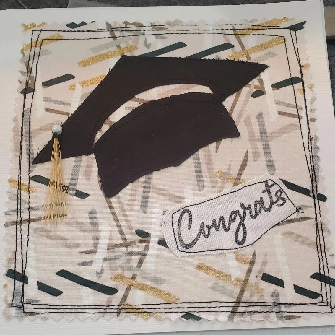 Handmade 6x6 graduation greeting card featuring leopard print fabric, a dimensional black graduation cap, and a stitched "Congratulations" message on a white cardstock background.