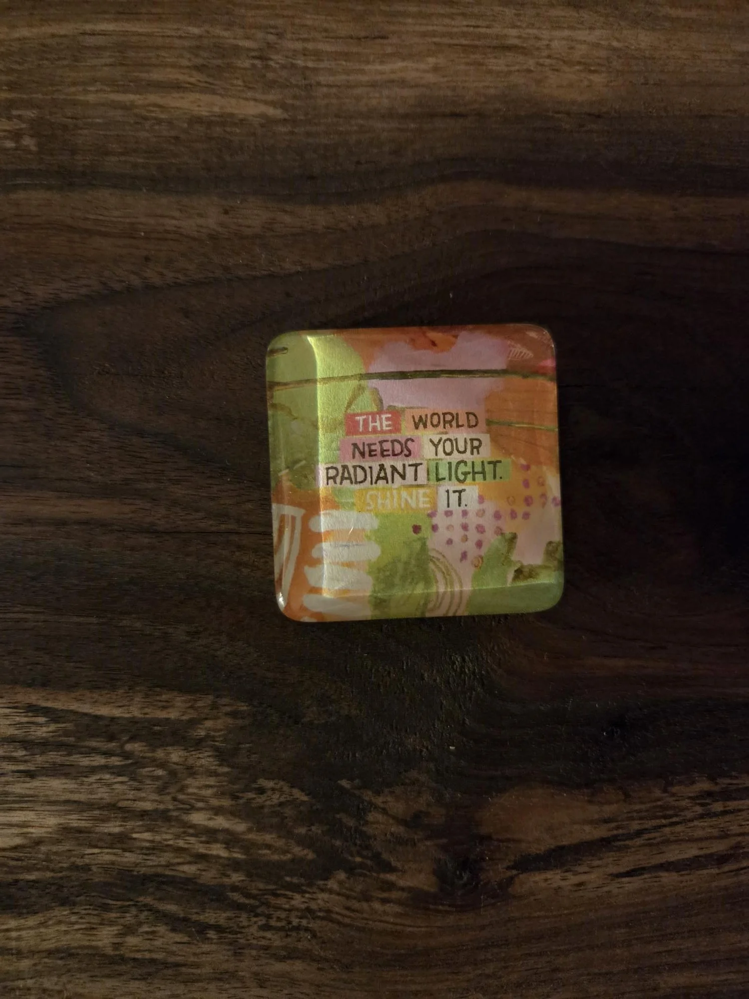 Handmade 2-inch crystal glass magnet featuring colorful abstract artwork with the inspirational quote, "The World Needs Your Radiant Light. Shine It."