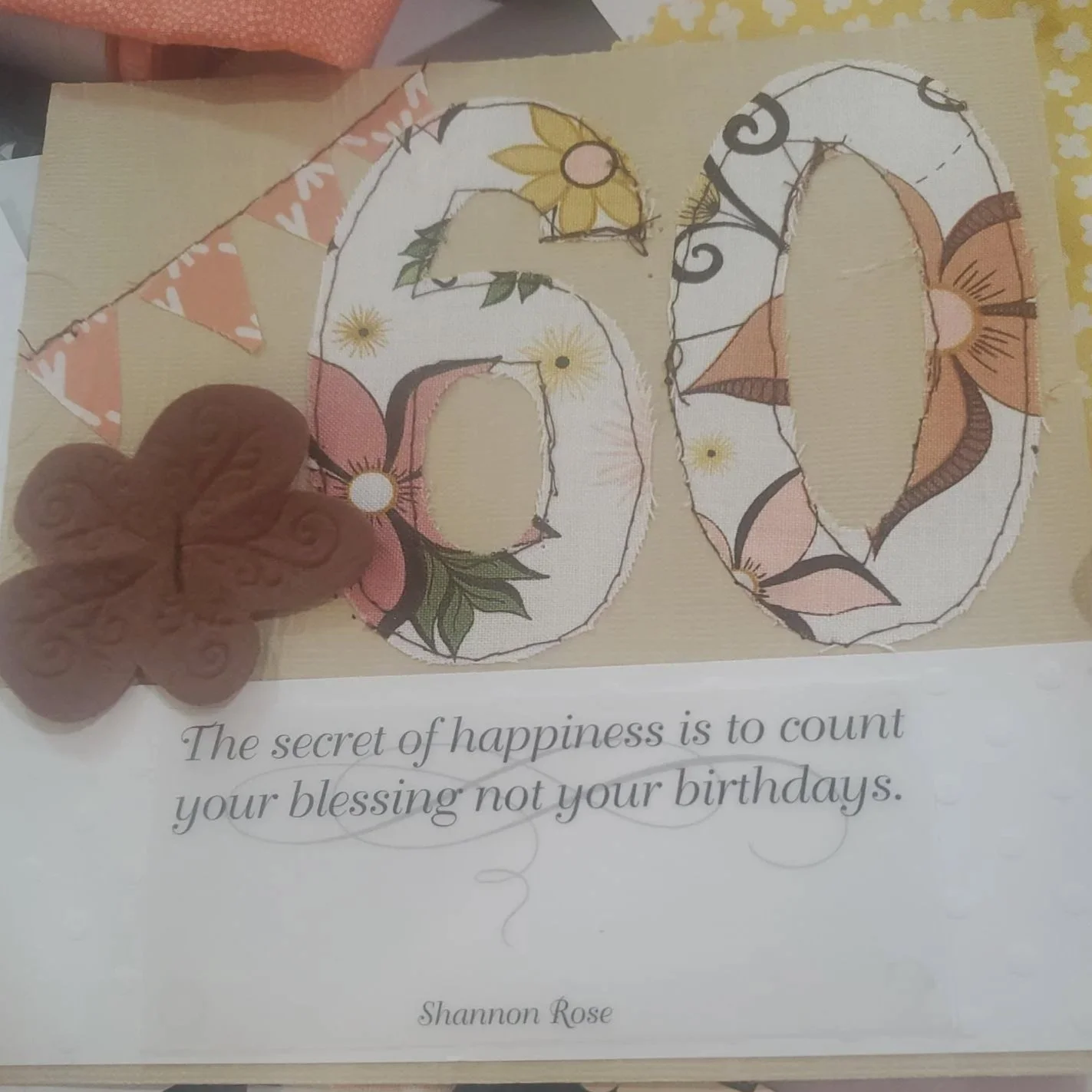 Handmade 60th birthday greeting card featuring stitched fabric appliqué numbers, butterfly embellishment, inspirational quote, and layered cardstock design.