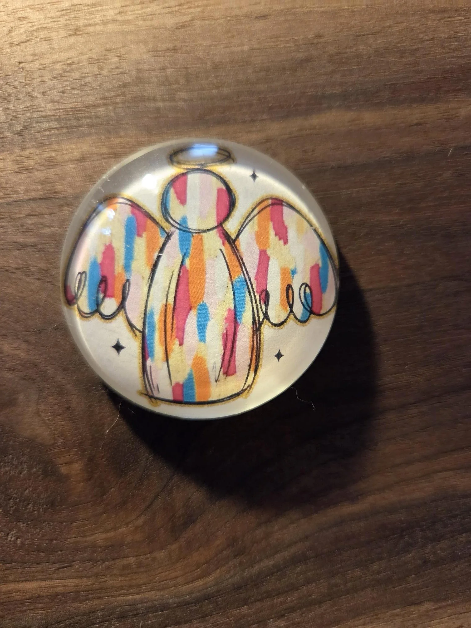 Handmade 2-inch round glass magnet featuring a colorful guardian angel illustration beneath a crystal-clear glass dome.