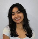 A young woman with long dark hair smiling at the camera, wearing a white top.