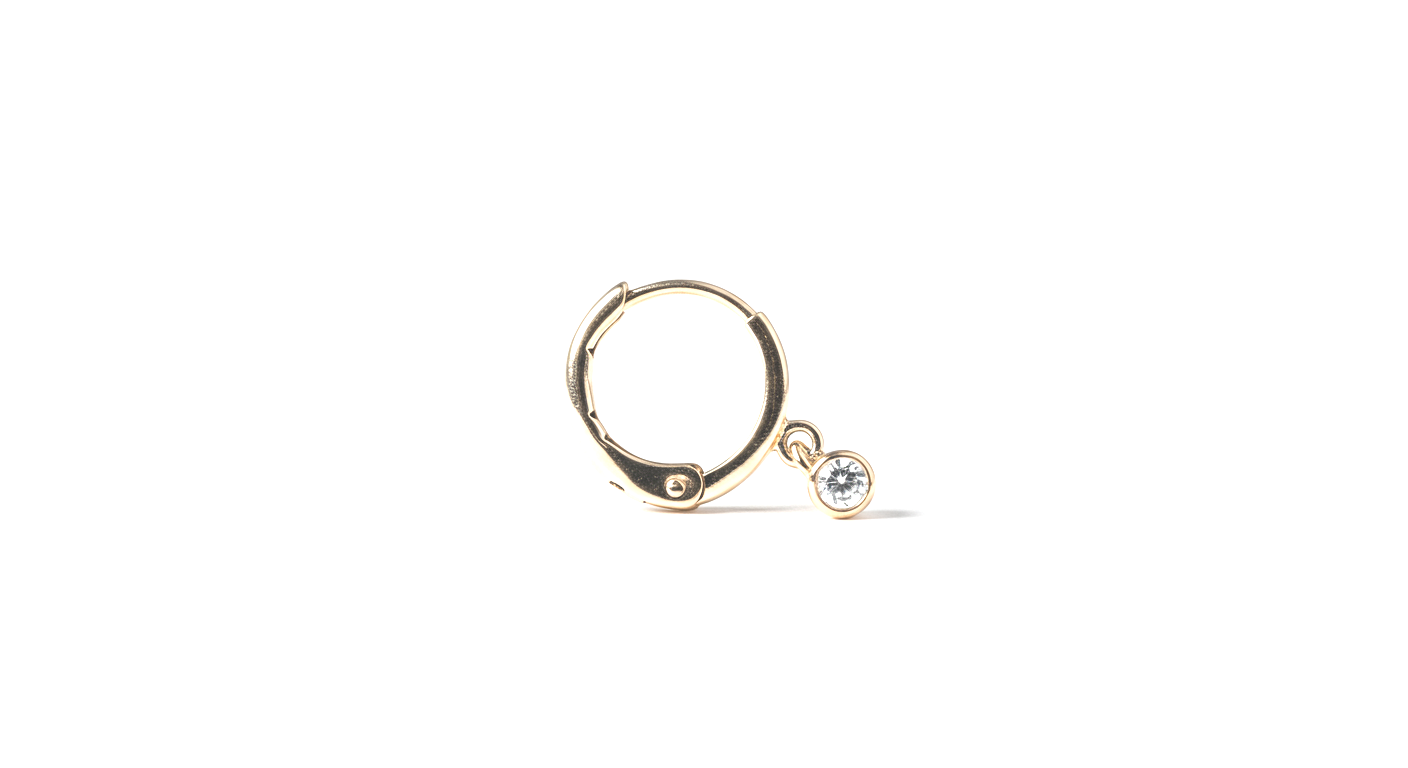 Close-up of a small gold hoop earring with a dangling clear gemstone on a white background.