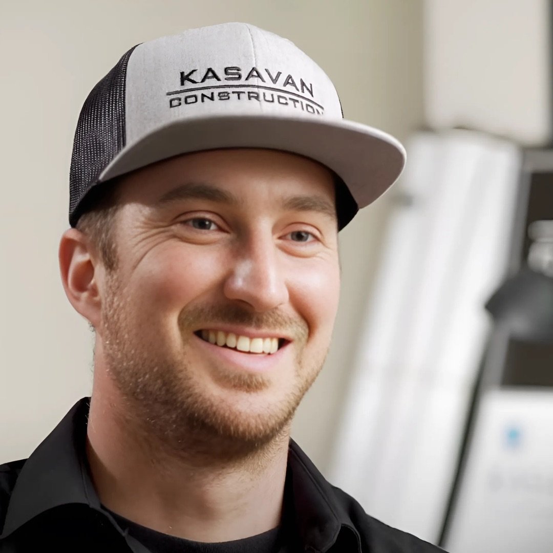 Founder of Kasavan Construction smiling wearing a hat and and a black shirt in an indoor setting.