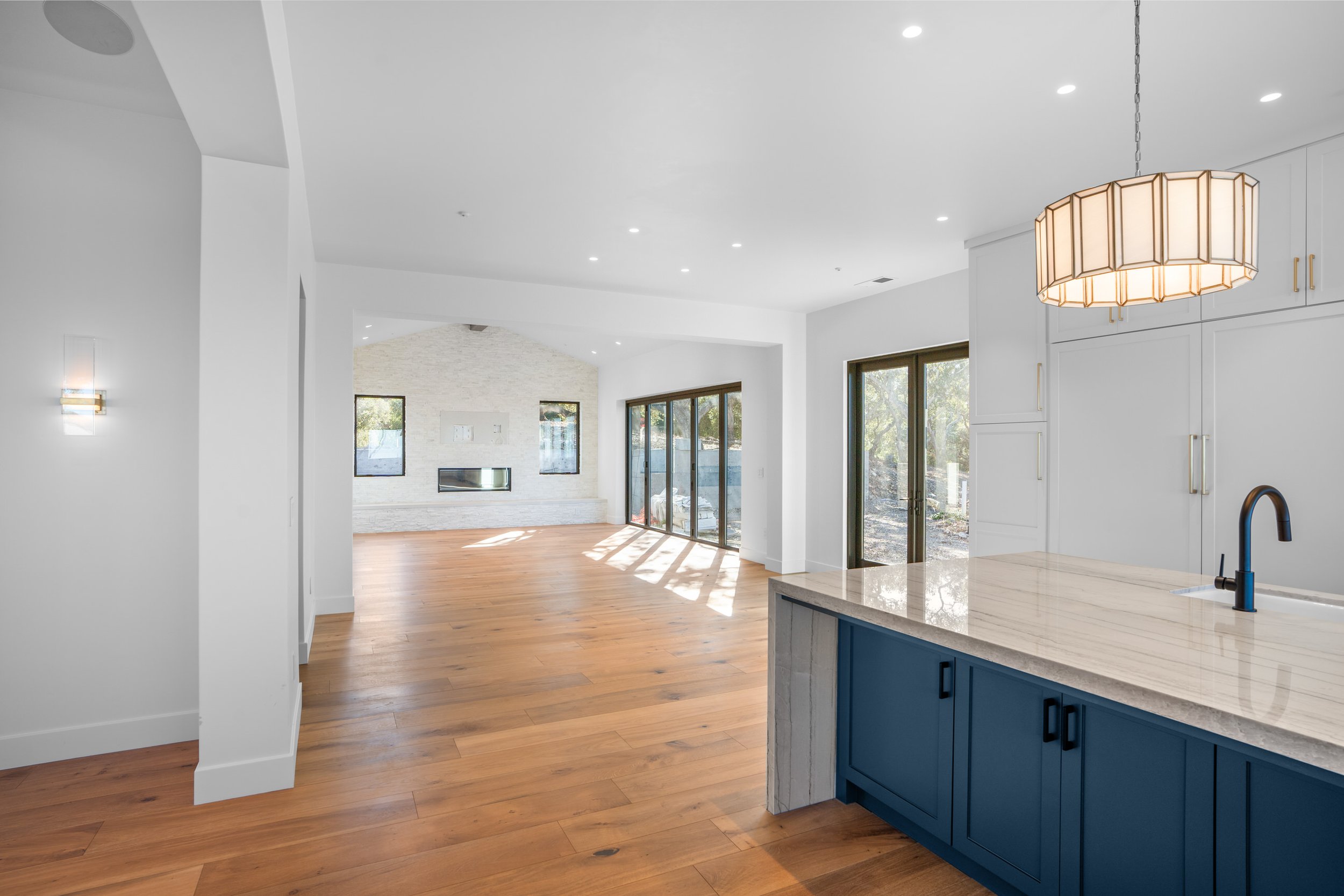 Open concept floor plan with wood floors, oversized island and natural light