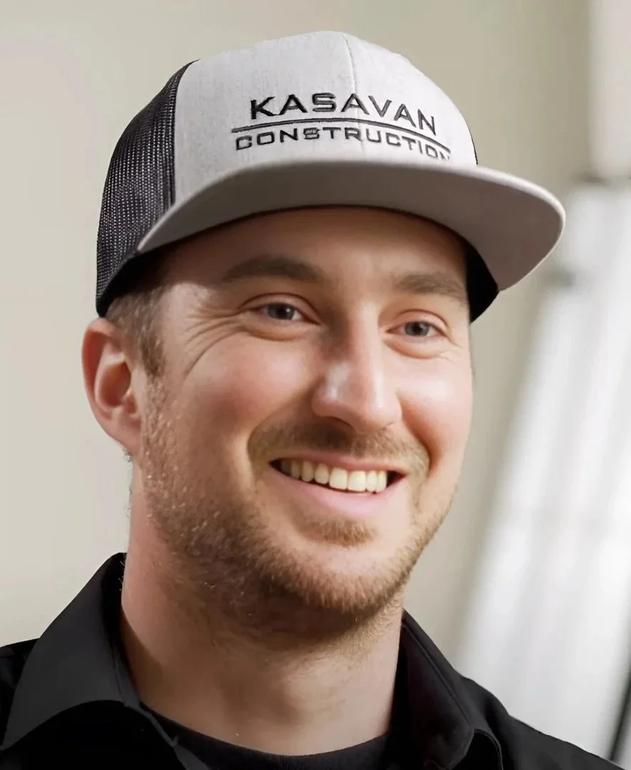 Founder of Kasavan Construction smiling wearing a hat and and a black shirt in an indoor setting.
