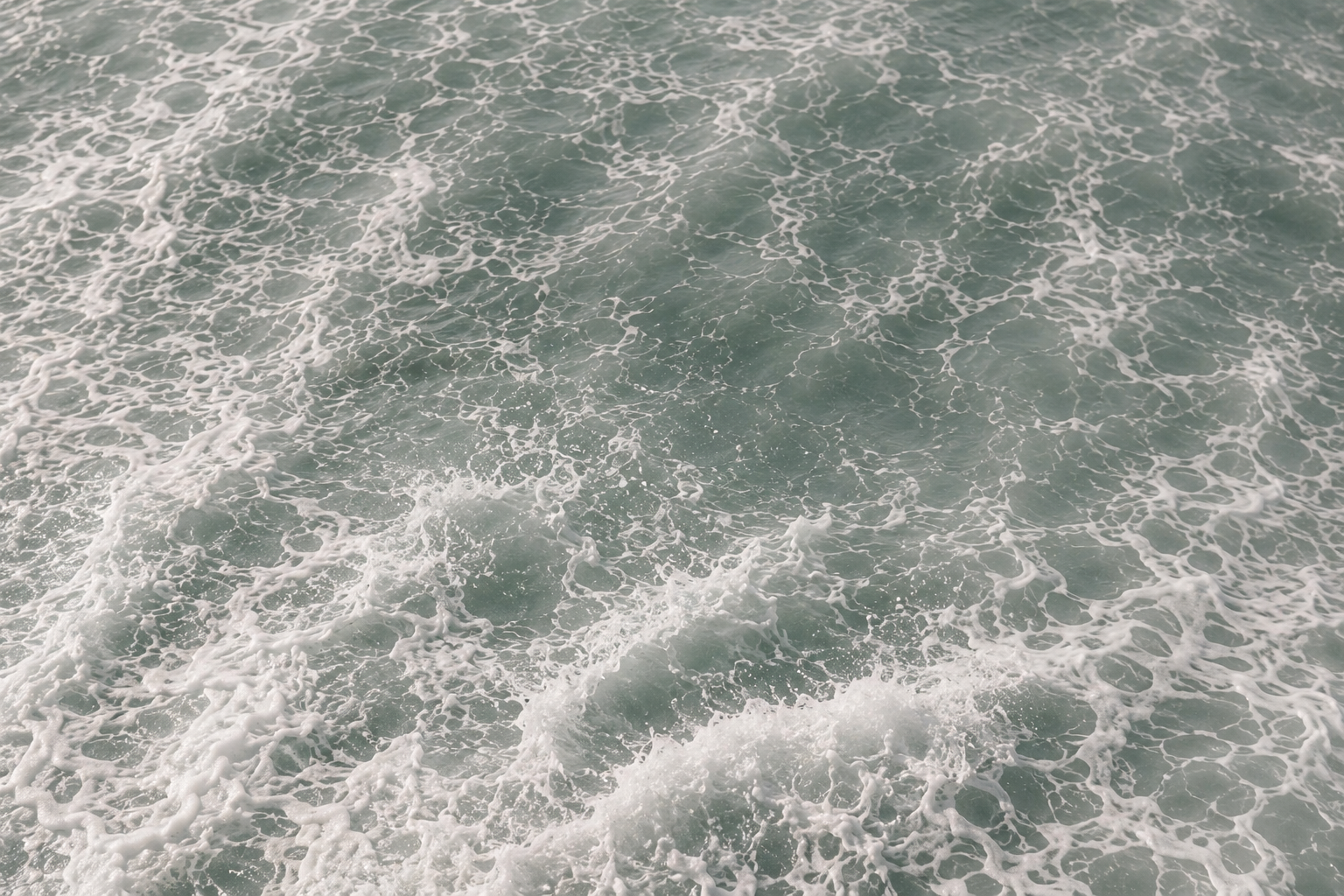 Ocean waves with white foam and turquoise water.