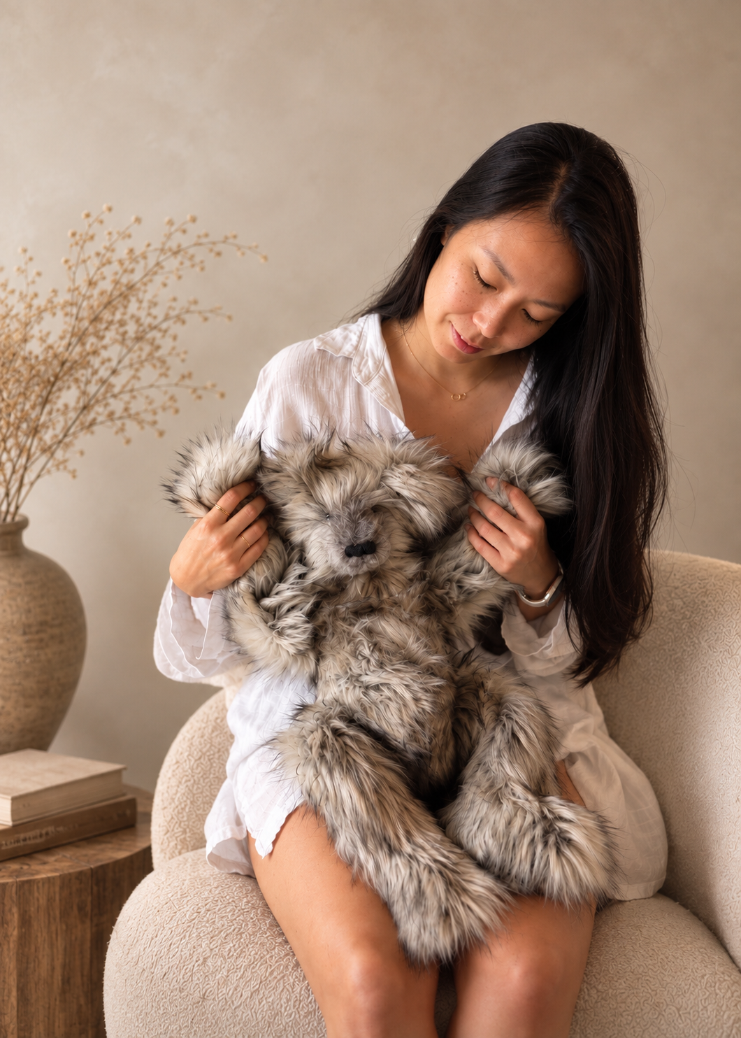 Catherine Ngo, plush artist and founder of The Cuddle Revival. Sitting with one of her original bears, a grey bear named Bear.
