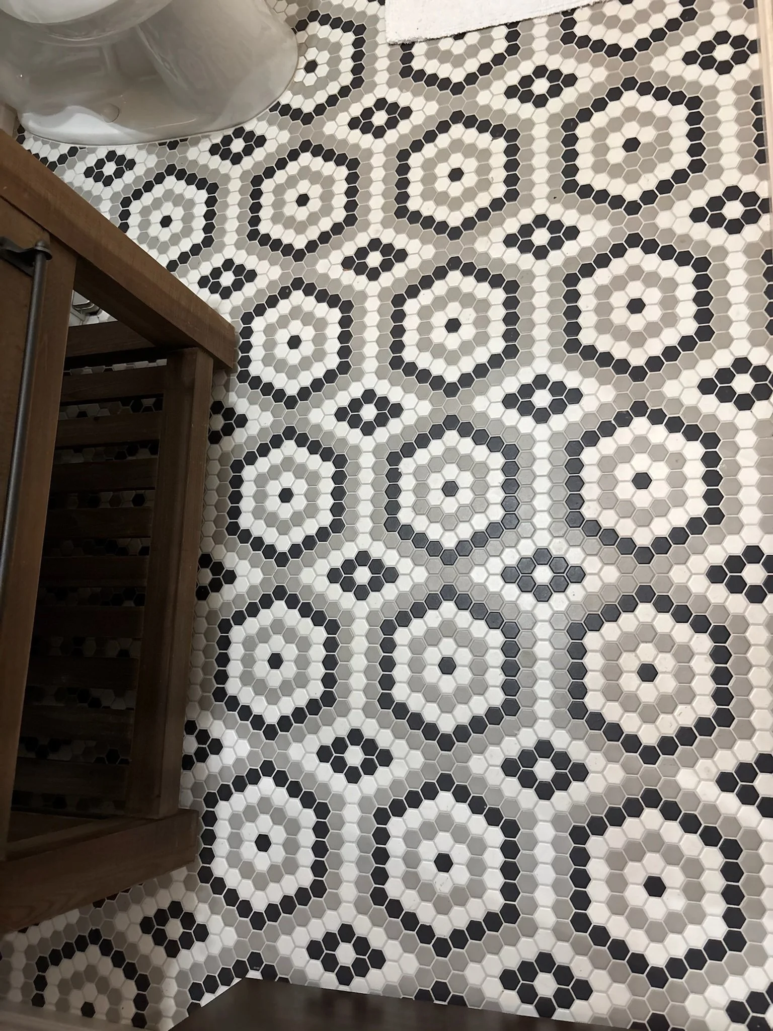 Floor with black, white, and gray hexagonal tiles arranged in a geometric pattern.