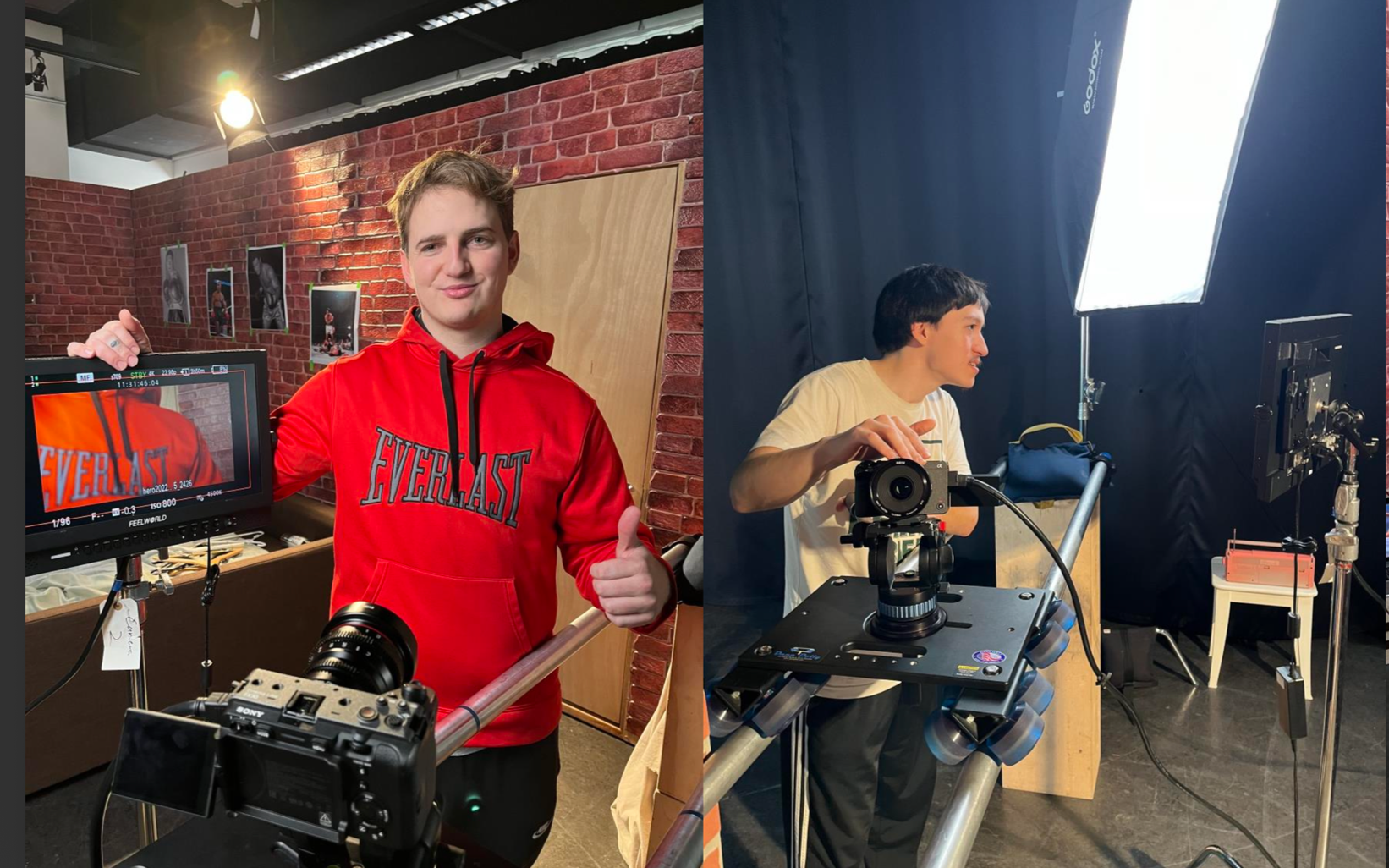 Two young men in a photography studio; one on the left with a red hoodie giving a thumbs-up, standing next to a camera monitor, and the other on the right wearing a white t-shirt, standing beside a camera on a tripod, with lighting equipment, black backdrop, and a small table with other photography gear behind him.