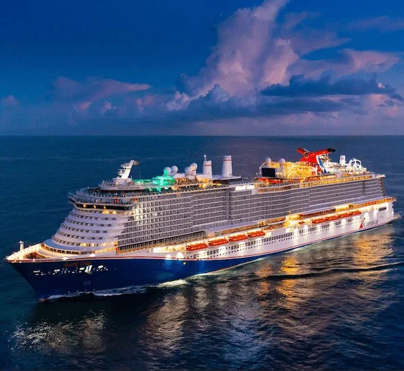 Large cruise ship with multiple decks sailing on the ocean during dusk, illuminated by colorful lights.
