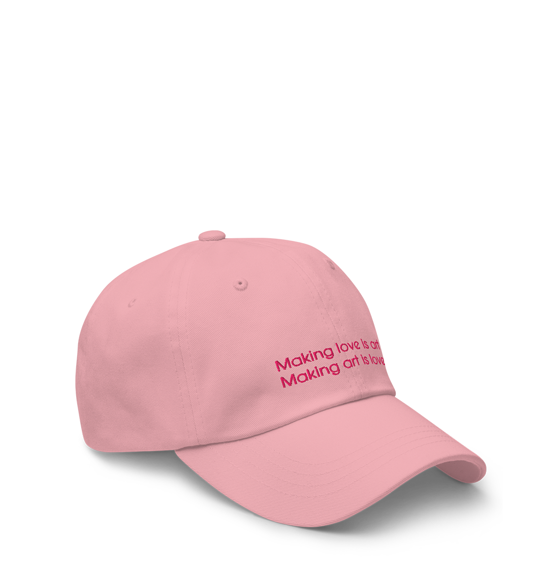 Light pink baseball cap with embroidered text 'Making love is art' on the front.
