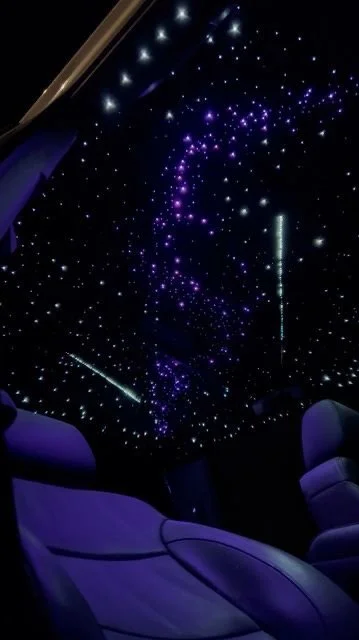 Intérieur d'une voiture avec un plafond éclairé par un ciel étoilé en LED.