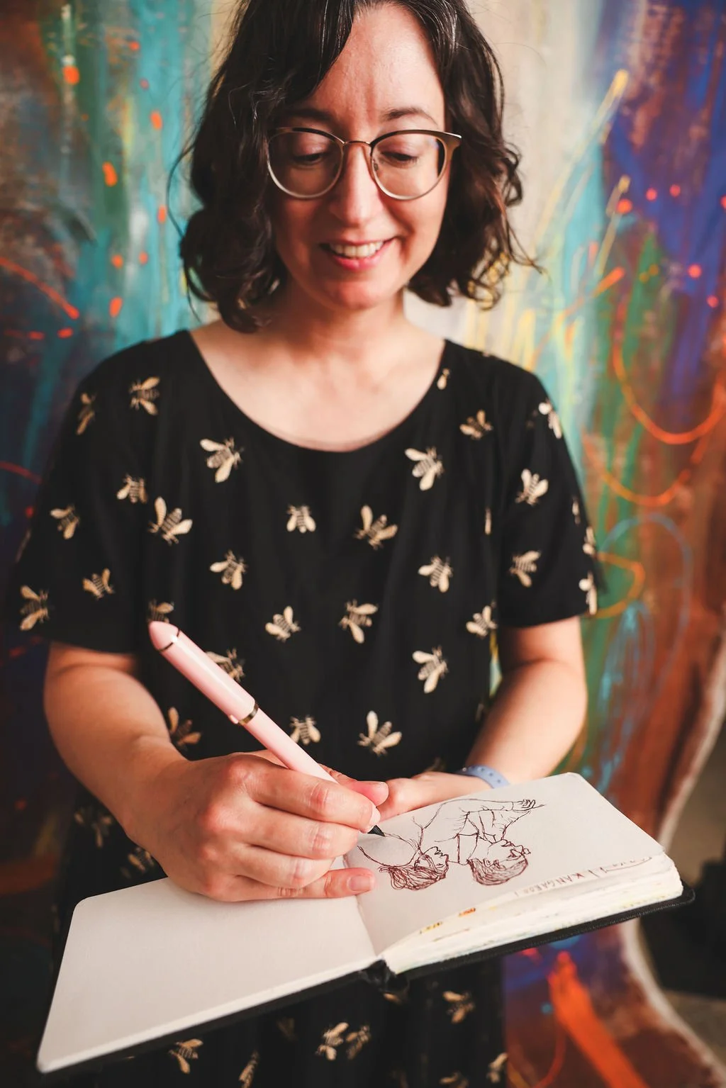 Rebecca Huval, grief therapist in Sacramento, sketches people in a sketchbook. Rebecca brings expressive arts into the therapy room to work with disenfranchised grief, including infertility, chronic illness, and pet loss.